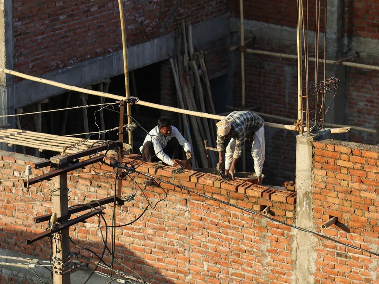 Maçons travaillant à la construction d’un mur en briques