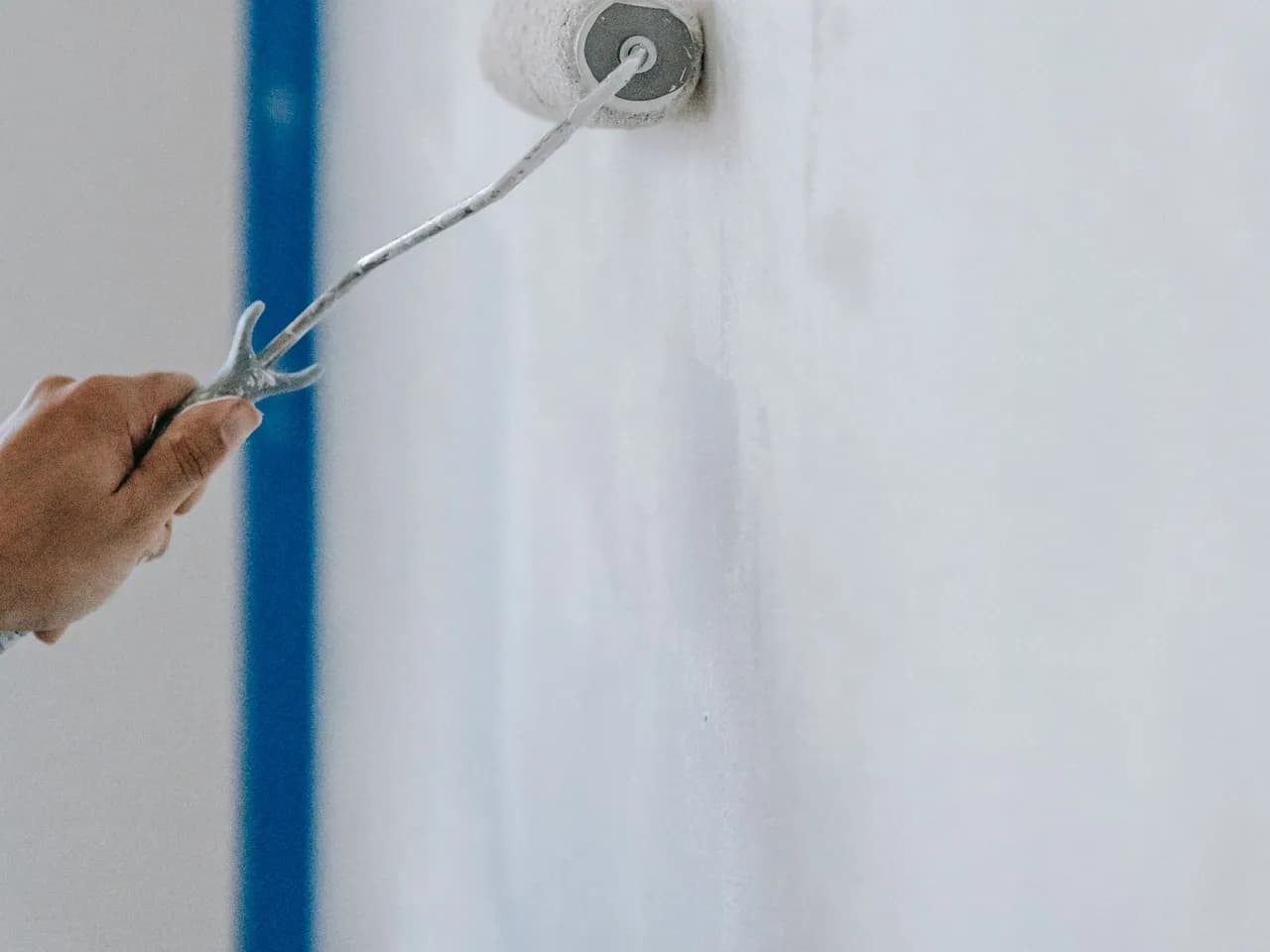 Application de peinture blanche au rouleau sur un mur intérieur