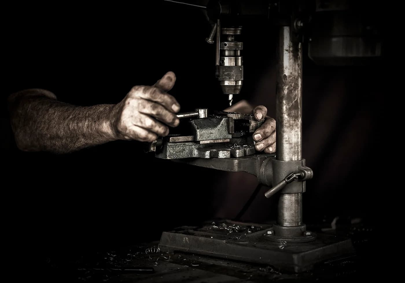 Un artisan utilise une perceuse à colonne dans un atelier