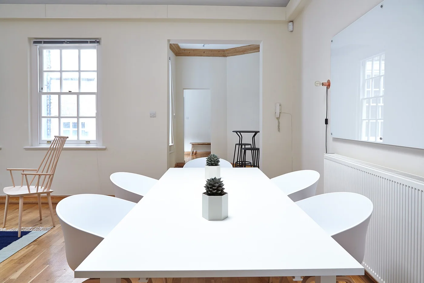 Une table de réunion blanche devant un tableau mural