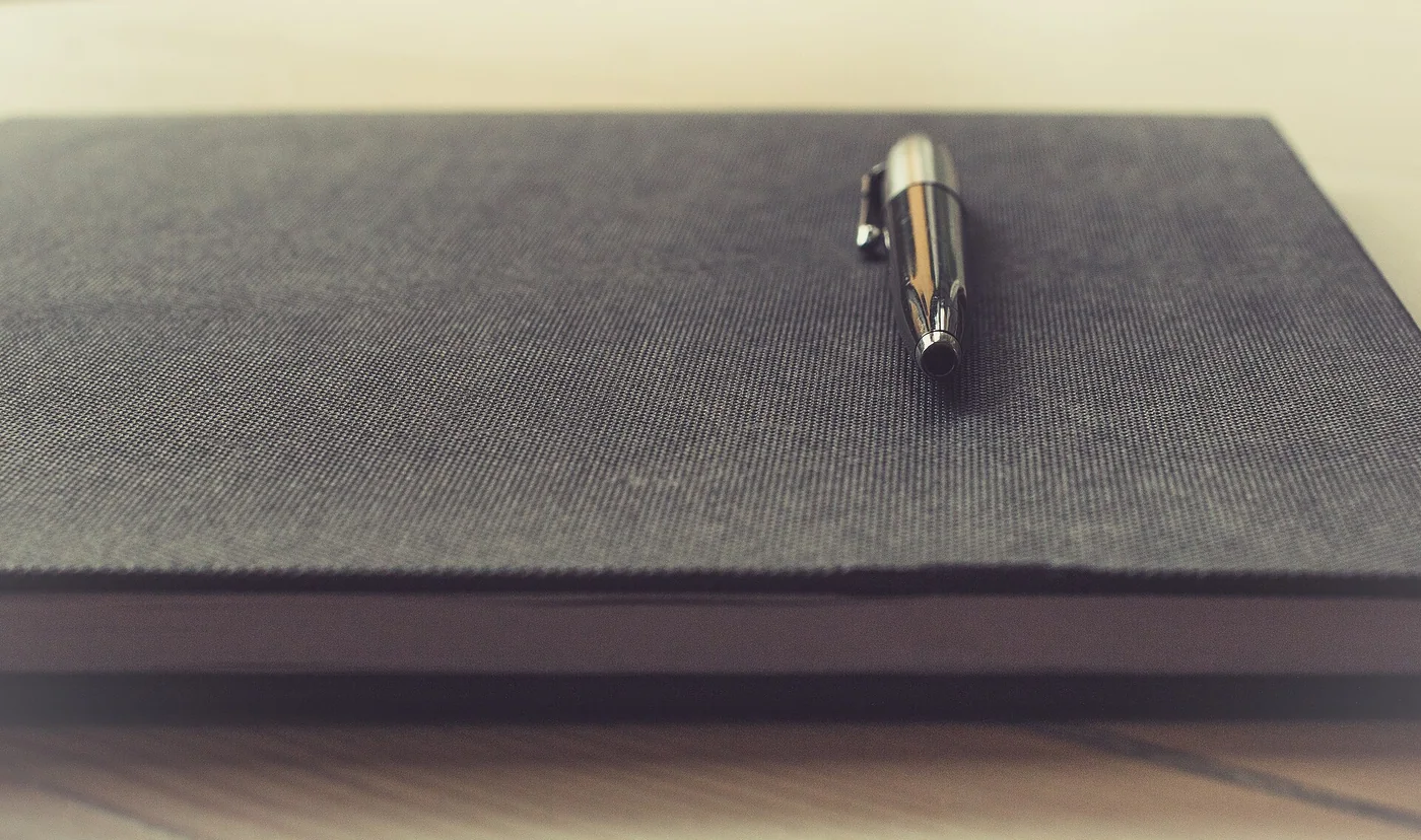 Un stylo posé sur un carnet fermé
