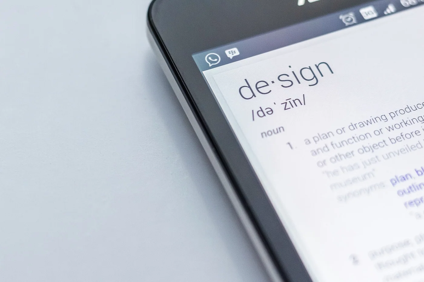Un smartphone posé sur une table avec le mot design à l’écran