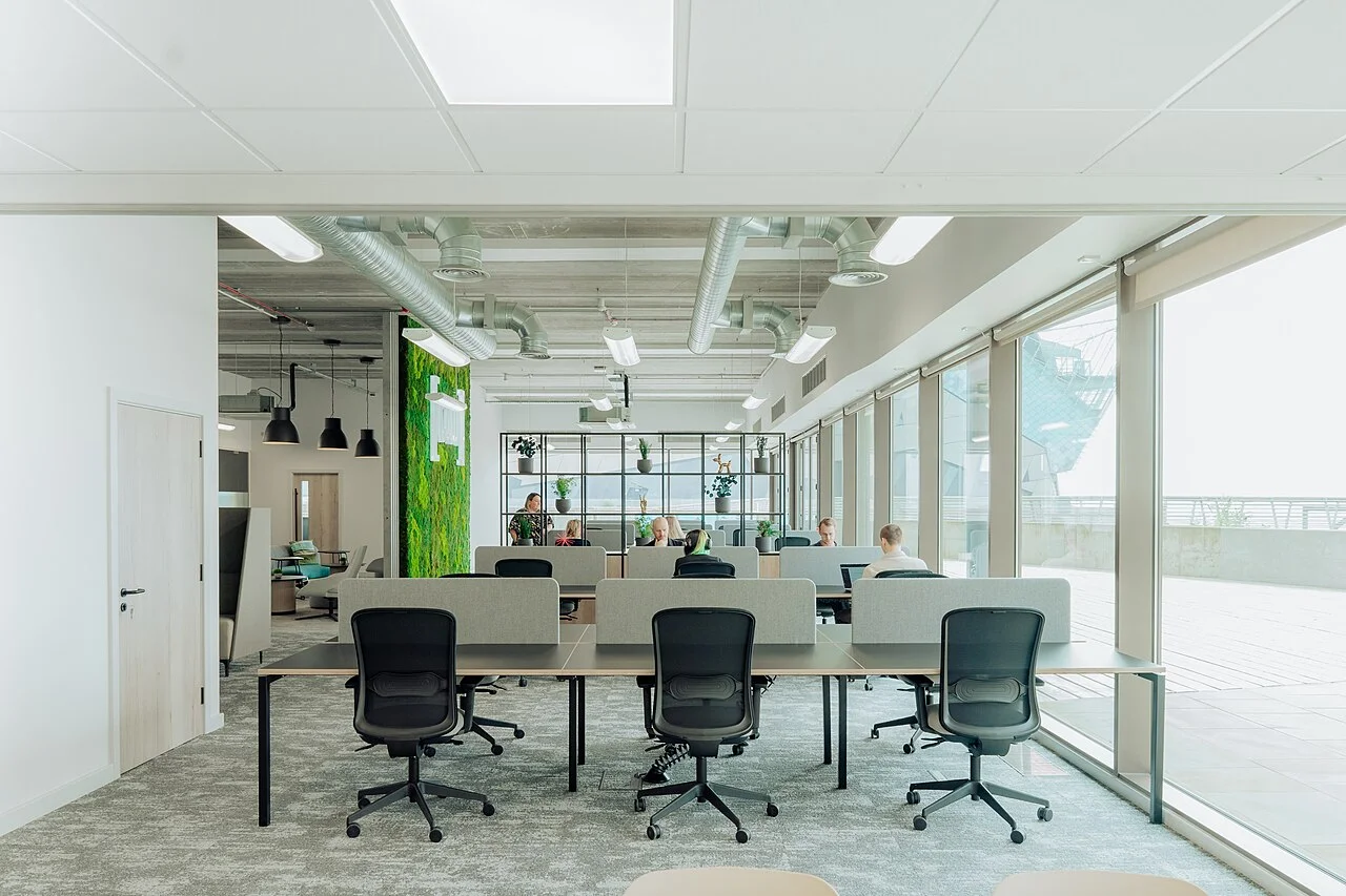 Salle de réunion vitrée entourée de bureaux