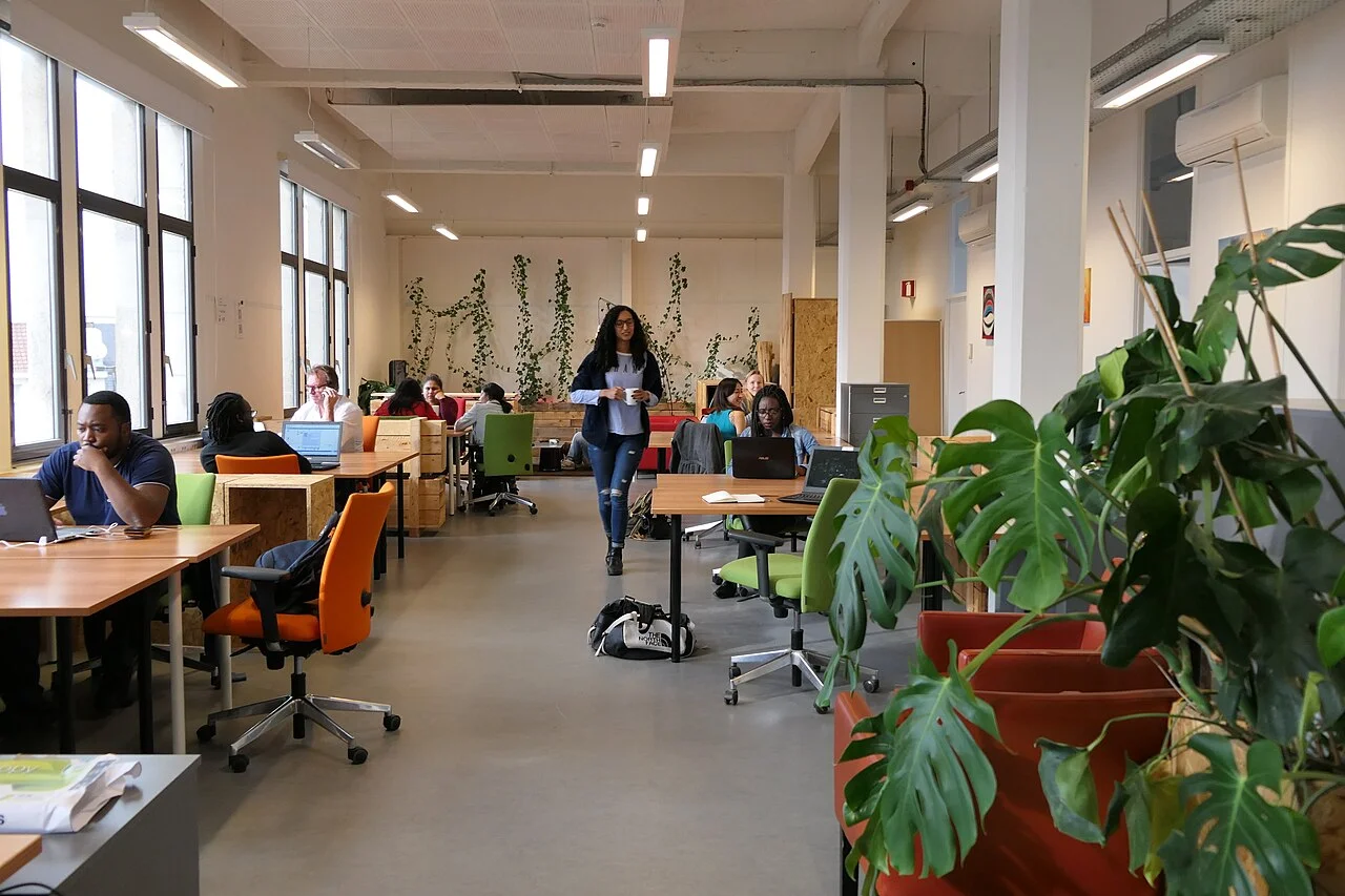 Espace de coworking ouvert avec tables et plantes